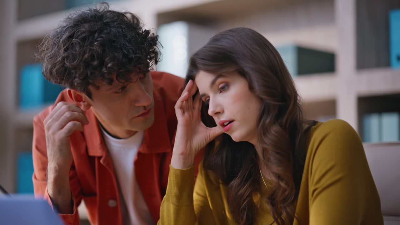 Two employees solving problem at laptop working together at coworking closeup