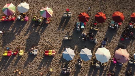 beach scene with people relaxing under colorful umbrellas