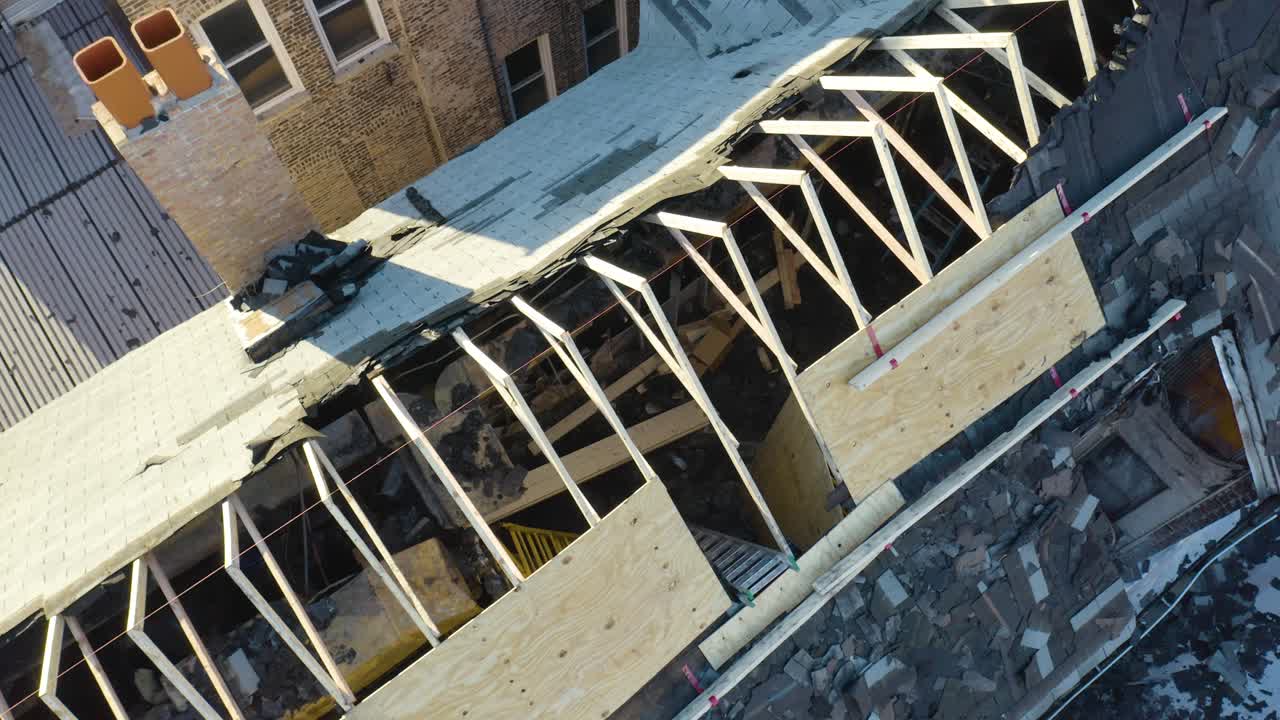 Drone backward moving shot of burned house roof during morning time