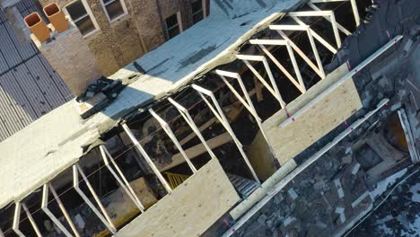 Drone-backward-moving-shot-of-burned-house-roof-during-morning-time