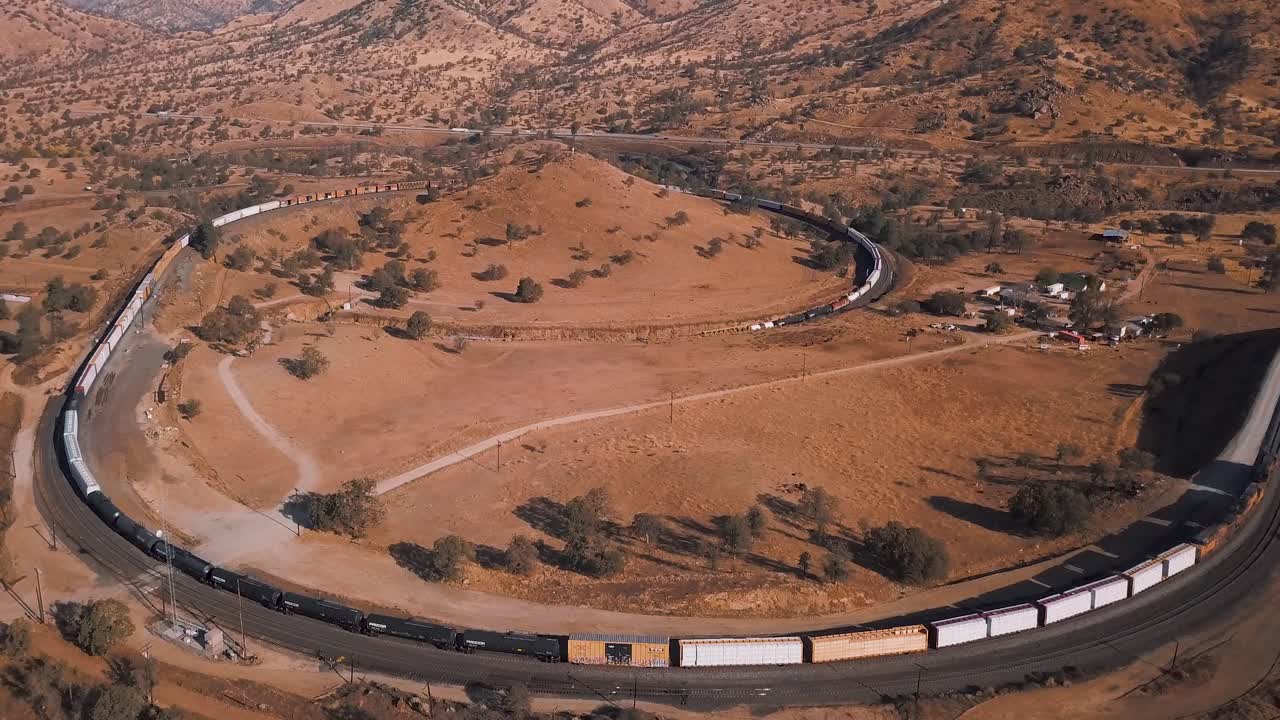 vista aérea del largo tren de carga que pasa por el circuito de tehachapi, california