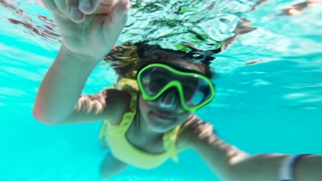 little girl swims underwater in an underwater panoramic mask. a child snorkels. bubbles surround the baby on all sides.