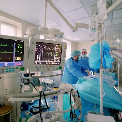 hospital monitor in the operating room. screen shows vital signs of a patient on the background of surgical procedure. teamwork of doctors