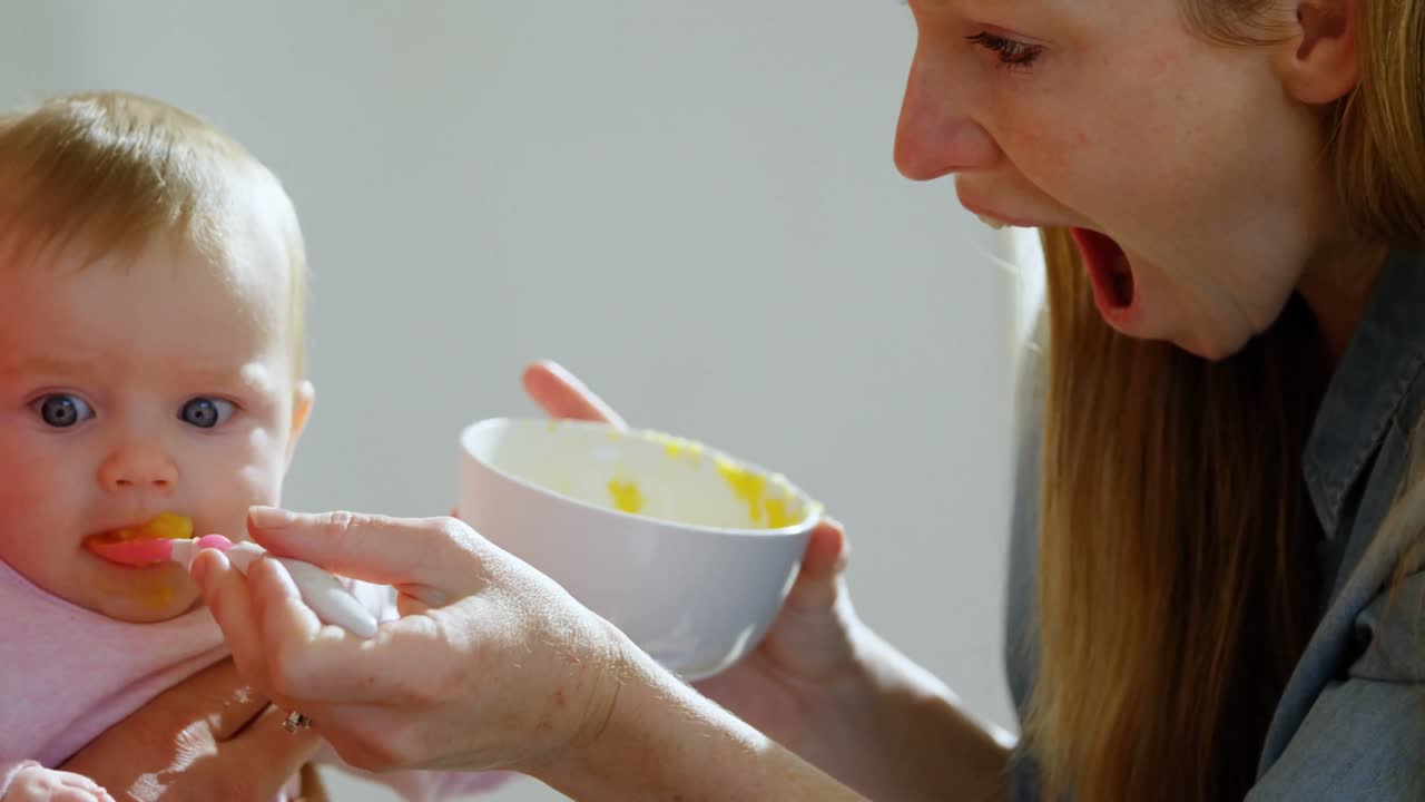 家で赤ちゃんに ⁇ をあげている両親 4k