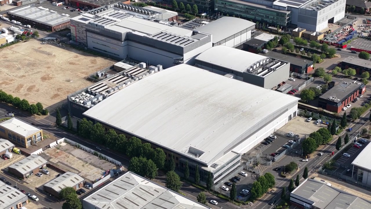 Aerial drone view of Slough industrial estate in the UK, featuring a major cluster of data centers, power infrastructure and facilities supporting AI, cloud computing and digital services.