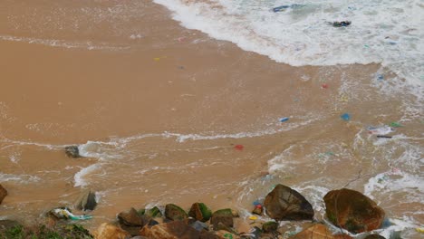 Plastic-pollution-in-the-sea,-washing-up-shore