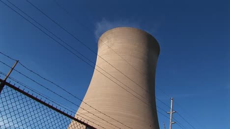 steam drifts slowly from the top of a nuclear power plant