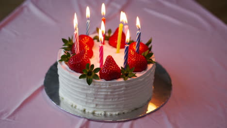 strawberry birthday cake with lit candles