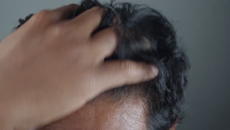 primer plano de un hombre arreglando su cabello