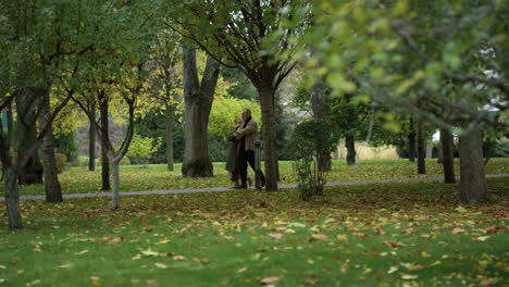 Close-up-view-of-autumn-nature-with-walking-couple-laughing-together-.