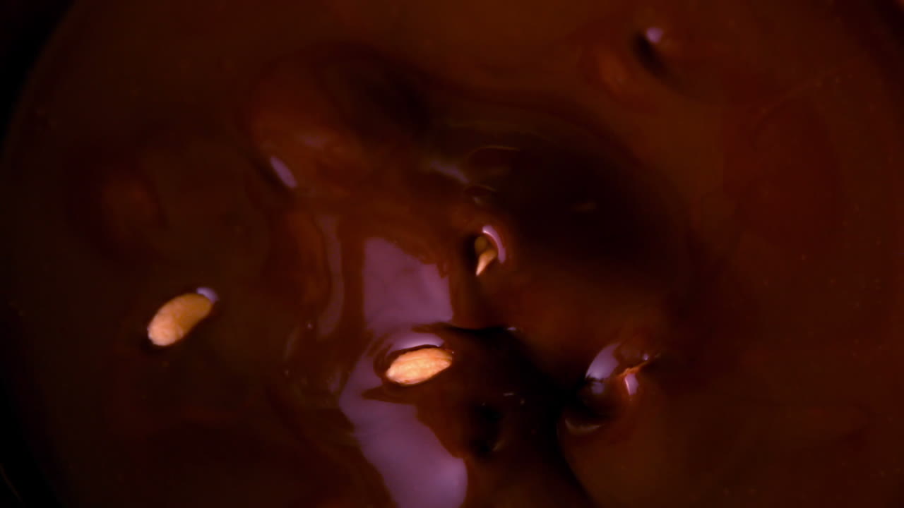 cacahuetes cayendo en el chocolate derretido