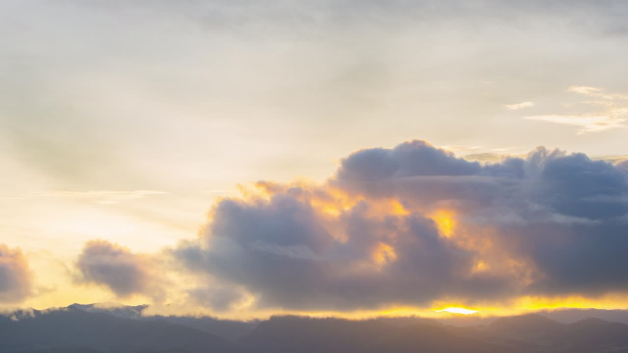 Time Lapse 4K of sunrise over mountains with sunbeam light passing through the clouds In the beautiful time of the morning, Srinakarin Dam, Kanchanaburi, Thailand.