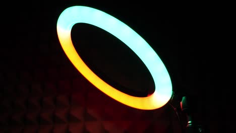 lámpara rgb de anillo luminoso. luz multicolor en una habitación oscura, primer plano.
