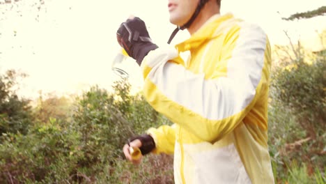 male mountain biker drinking water in the forest