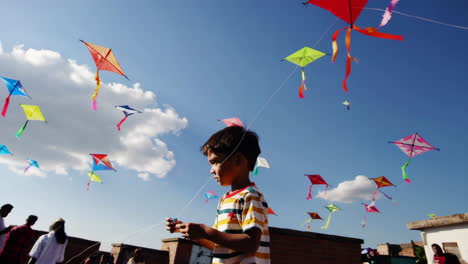 a boy flying colorful kites under a clear blue sky