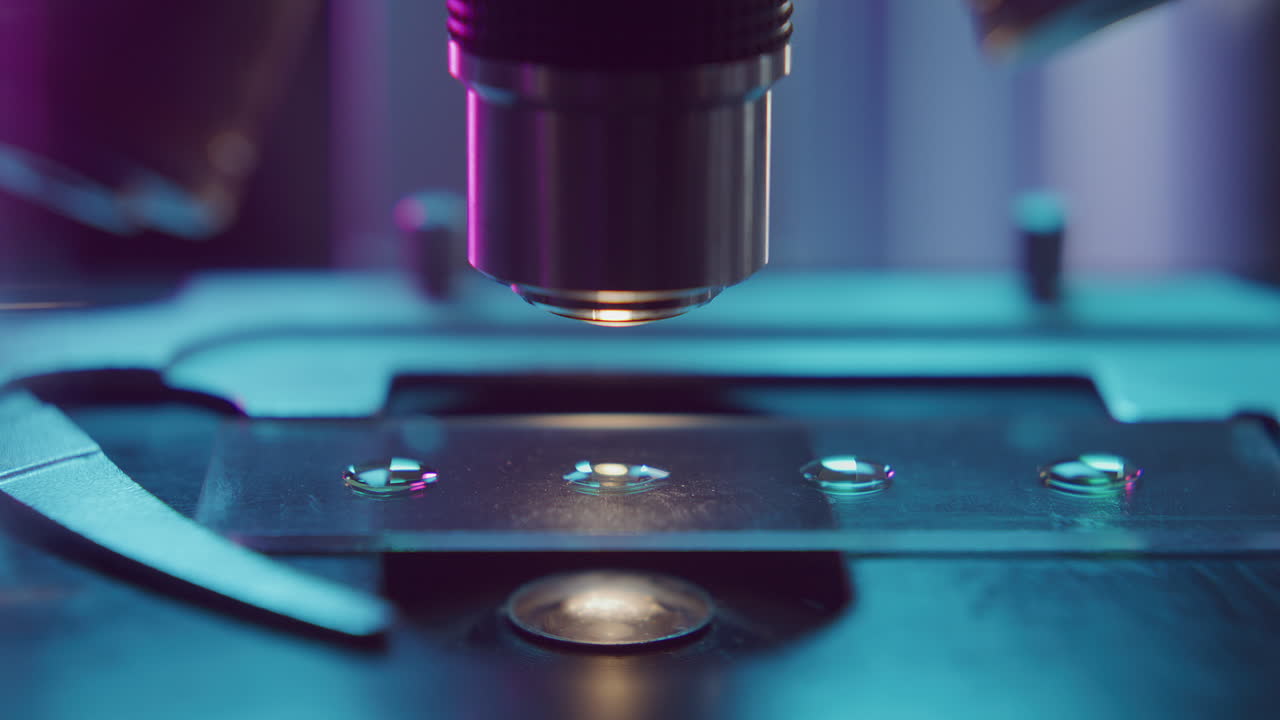 Focusing Microscope Lens on Slide with Droplets during Lab Examination
