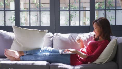 Mixed-race-woman-using-a-laptop.-Social-distancing-and-self-isolation-in-quarantine