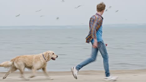 teenage boy running with golden retriever dog