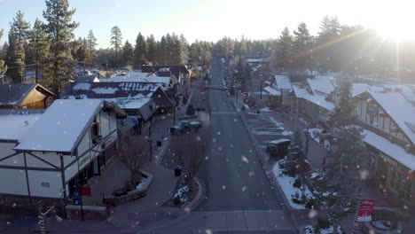 Drohnenantenne-Am-Frühen-Morgen-Zwischen-Der-Big-Bear-Lake-Street,-Ca-Mit-Winterlichem-Schneefall---Sonnenscheinfackeln