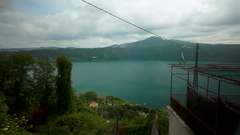 scenic view over lake albano surrounded by forested hills and cloudy skies in castel gandolfo.
