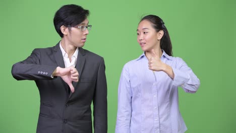 young asian business couple having different decisions together