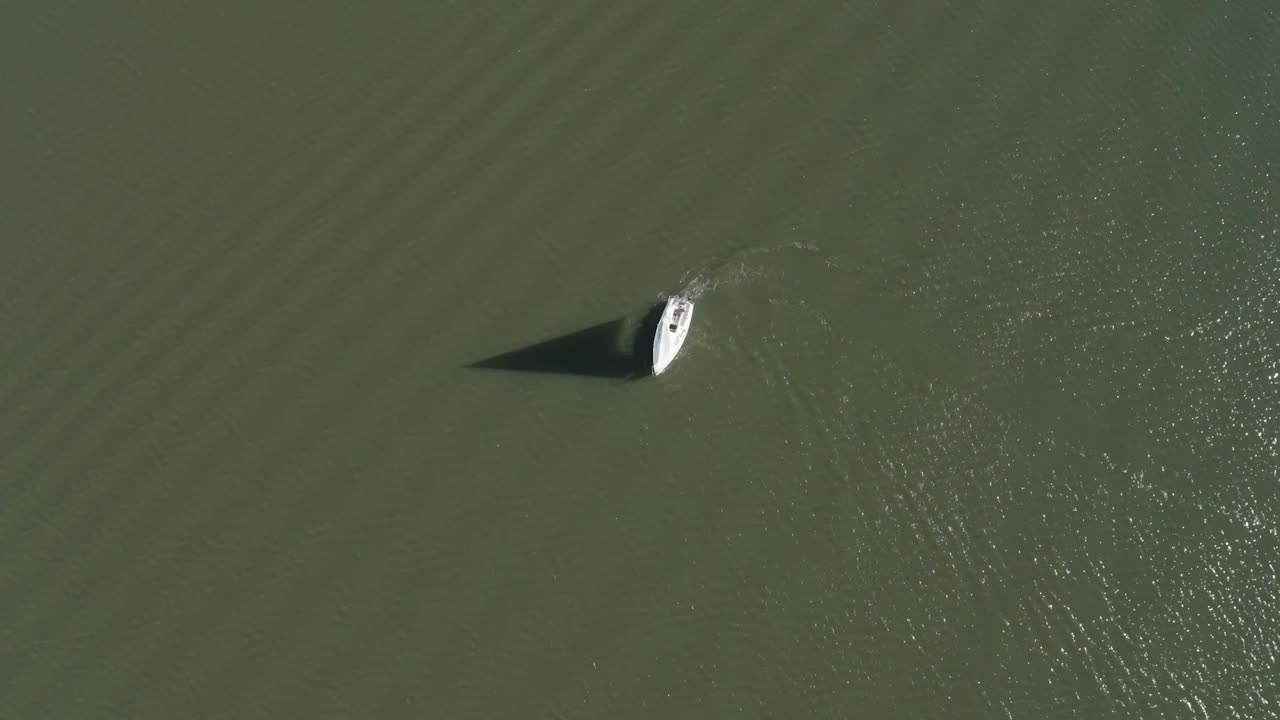 Ripresa con drone di una barca a vela che vira in un lago.