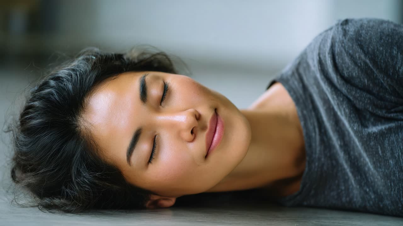 Un momento tranquillo catturato in due inquadrature, che mostra una giovane donna serena che riposa placidamente sul pavimento con un'espressione delicata di calma e relax.