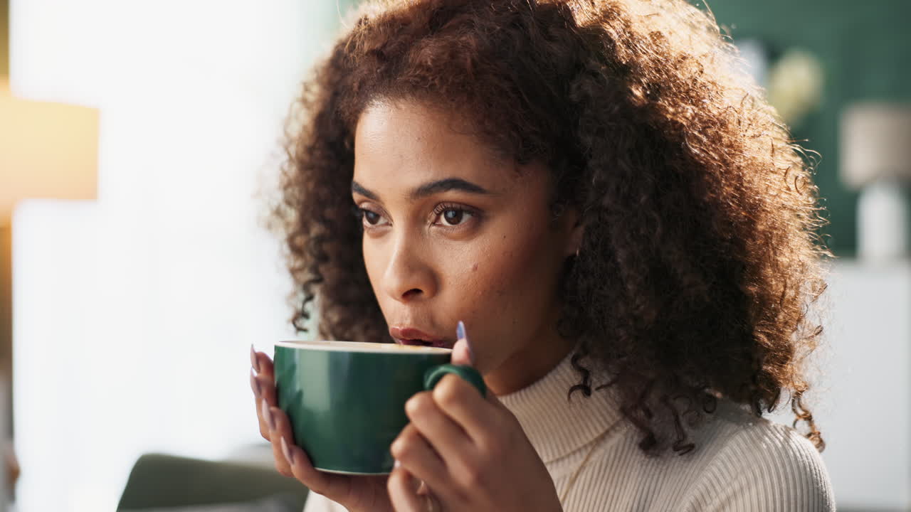 Woman with curly hair drinking from a cup