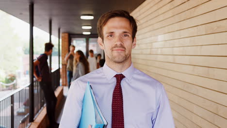 Portrait-Of-Teacher-Walking-Into-Focus-Outside-School-Building