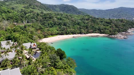 drone footage captures lush greenery, turquoise waters, and beachfront resorts in phuket, thailand, showcasing serene coastal beauty