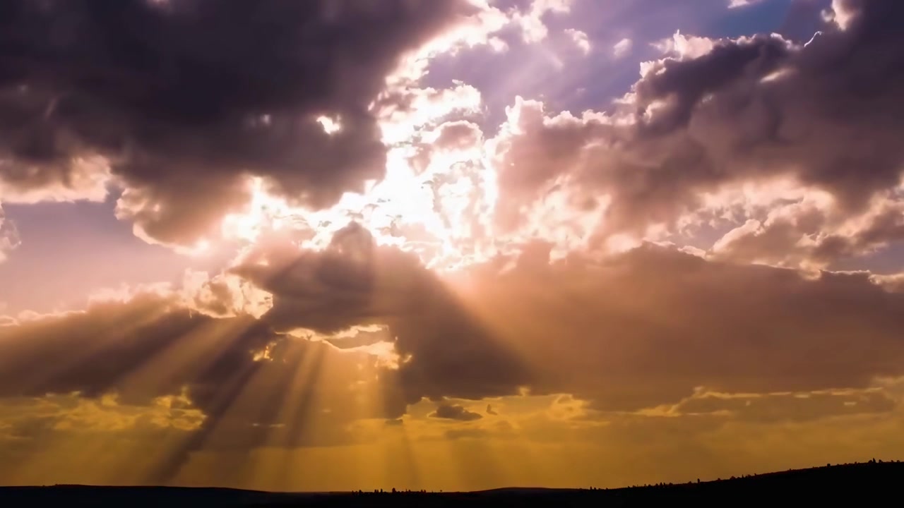 Raggi di sole dorati che filtrano attraverso nuvole scure al tramonto.