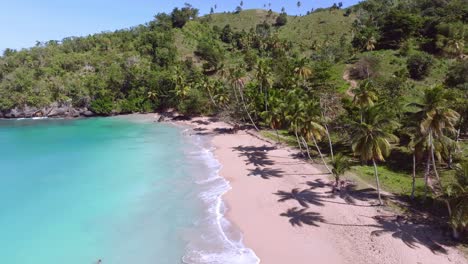 Lonely-tourist-enjoys-beach-day-in-empty-tropical-paradise-surrounded-by-palms