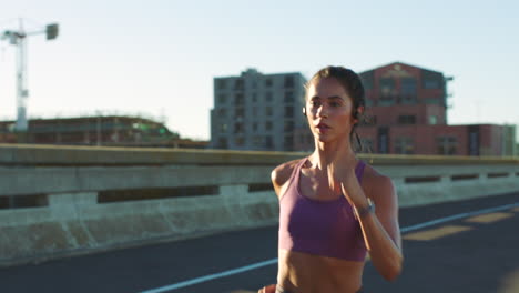 mujer corriendo en un puente de la ciudad