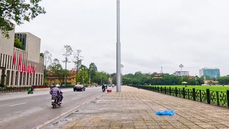 motorbikes and cars pass by iconic buildings