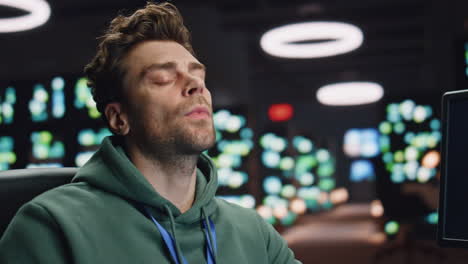 overworked analyst drinking coffee coding at computer data center workplace