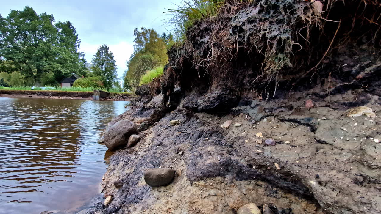 Calm riverbank in Cesis, Latvia creates a tranquil, natural scene outdoors