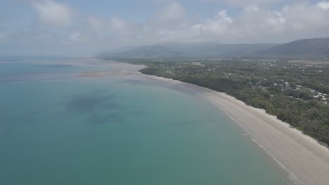 Blauer-Ozean-Und-üppiger-Wald-Des-Viermeilenstrandes-Unter-Dem-Wolkigen-Blauen-Himmel-In-Port-Douglas,-Im-Hohen-Norden-Von-Queensland-In-Australien