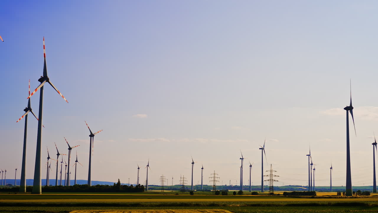 Beautiful field with multiple wind turbines. Wind farms at sunset. Green energy concept.