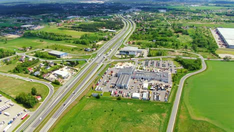 buildings of logistics center, warehouses near the highway, view from height, a large number of trucks in the parking lot near warehouse