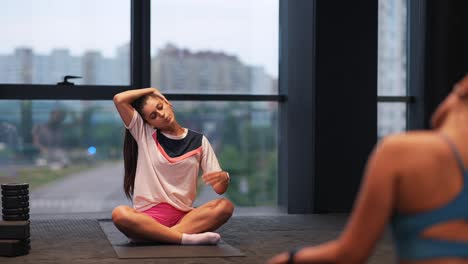 mujer estirándose en el gimnasio