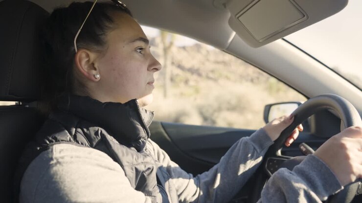 Ragazza che guida un'auto nel deserto di Joshua Tree, in viaggio negli USA
