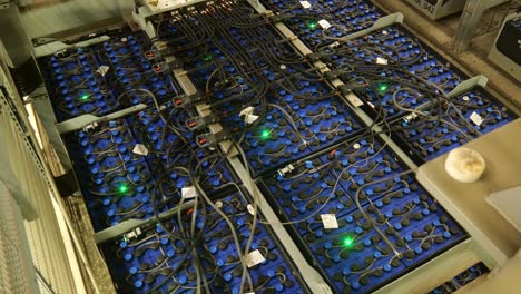 filas de paquetes de baterías dispuestas y conectadas entre sí con cables y luz de estado led verde