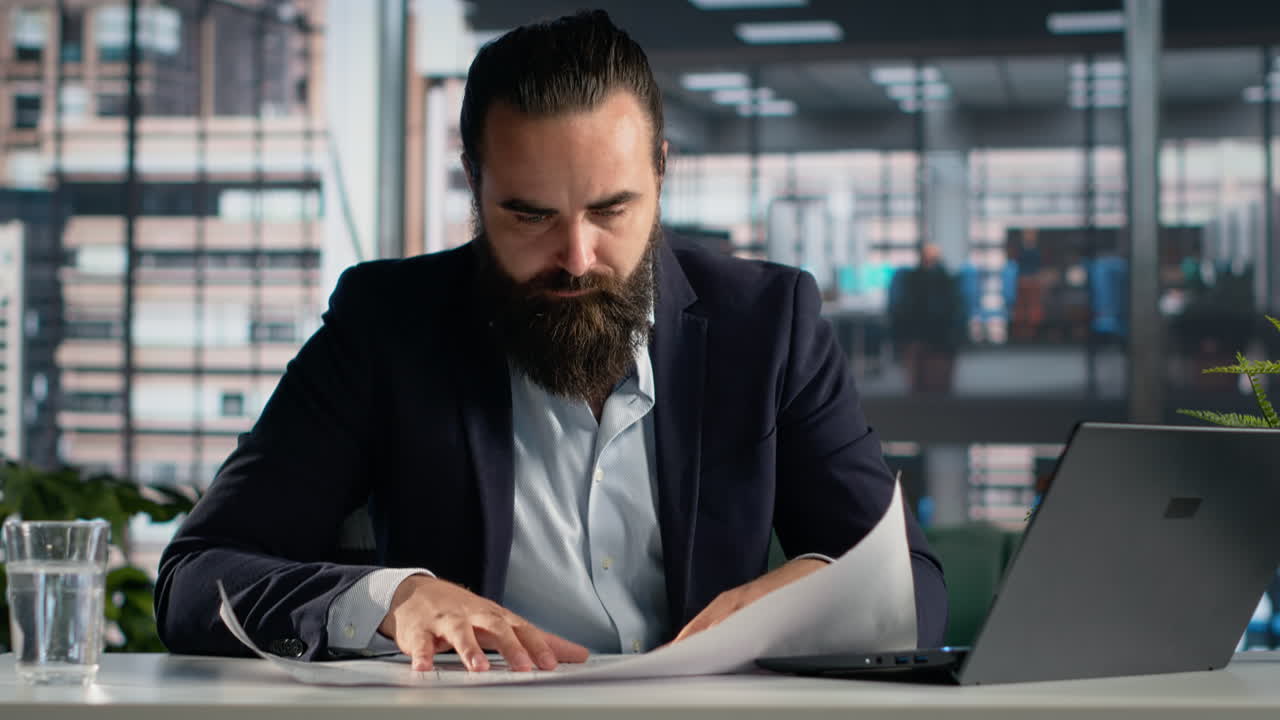 Ofis değişikliği için kiralık mimari planları inceleyen iş adamı