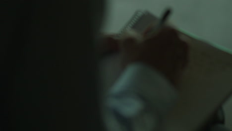 persona que escribe en un cuaderno