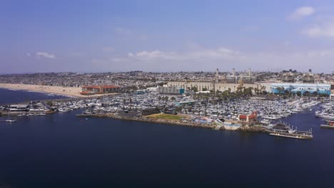 Toma-Aérea-Baja-Sobrevolando-La-Bahía-En-El-Puerto-Deportivo-King-Harbor-En-Redondo-Beach,-California