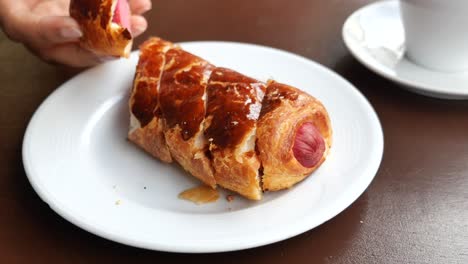 a close-up of a delicious sausage roll with coffee