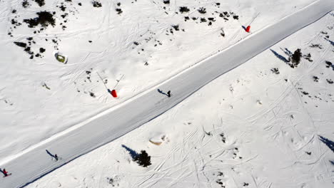 aerial view over people skiing down a mountain ski slope, on a sunny winter day, in slovakia