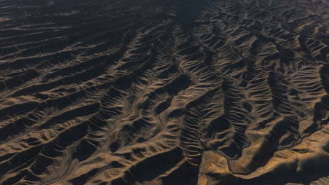 cinematic aerial of strange barren landscape of ridges and valleys, factory butte, utah