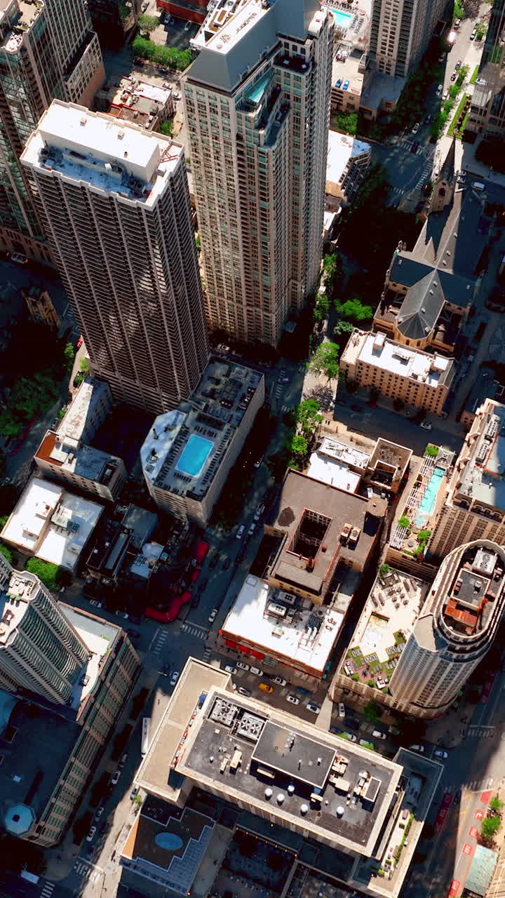 Visão aérea dos telhados de arranha-céus com piscinas, aparelhos de ar condicionado no centro de Chicago. Sobrevoo pelas ruas da cidade. Vídeo vertical
