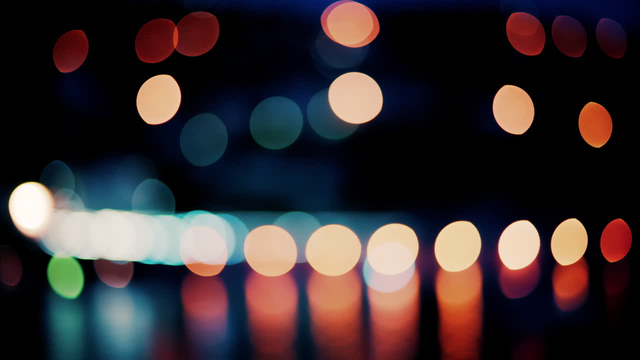 Blurry, circular light patterns in various warm and cool tones, set against a dark background